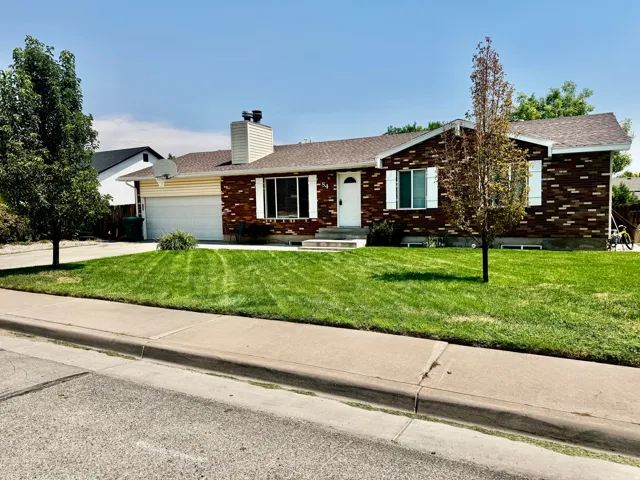 Brick and siding exterior with a single-car garage and a paved driveway