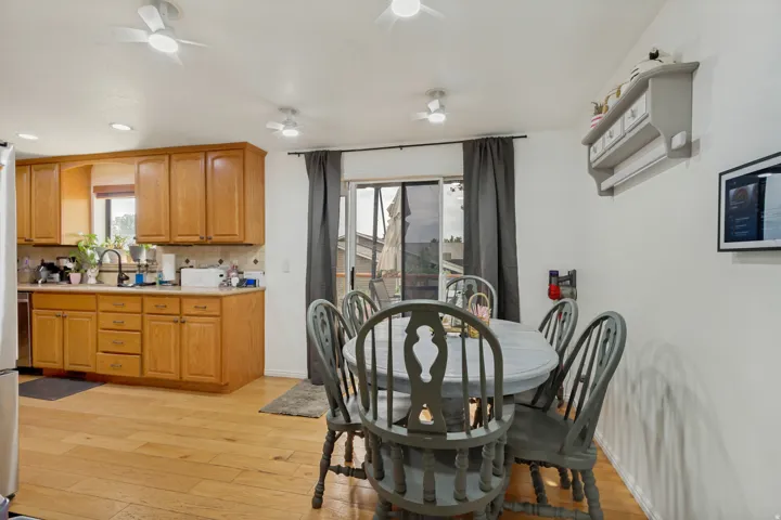 Kitchen with wood-finish flooring, wood cabinetry, and a tile backsplash