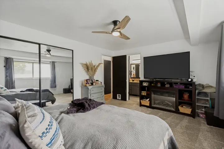 Recessed lighting, wood-finish ceiling fan with integrated lighting, wall-to-wall carpeting, and mirrored closet doors