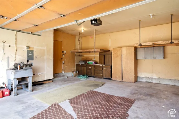 Concrete flooring with built-in cabinetry and overhead lighting