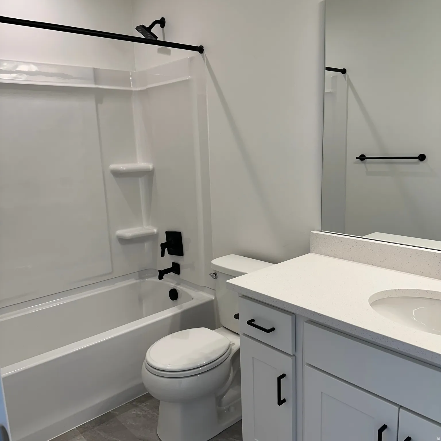 White vanity with recessed panel cabinetry and black hardware