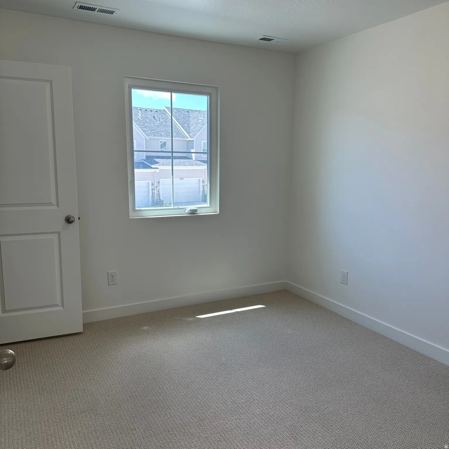 Neutral carpet flooring and white painted walls