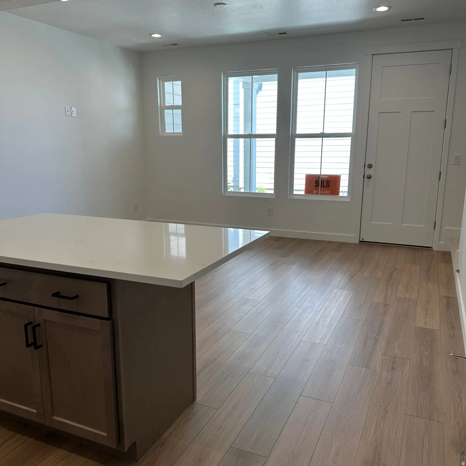 Kitchen island with a light-toned countertop and wood-finish cabinetry
