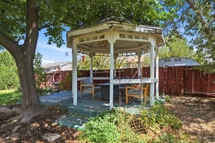 Built-in gazebo featuring a wood deck and surrounding mature foliage