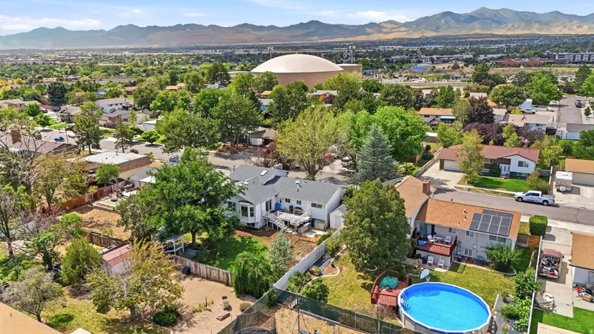 Residential architecture with a deck, a fenced yard, and an above-ground pool
