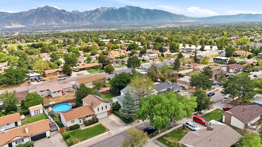 Residential neighborhood with established trees and mountain backdrop