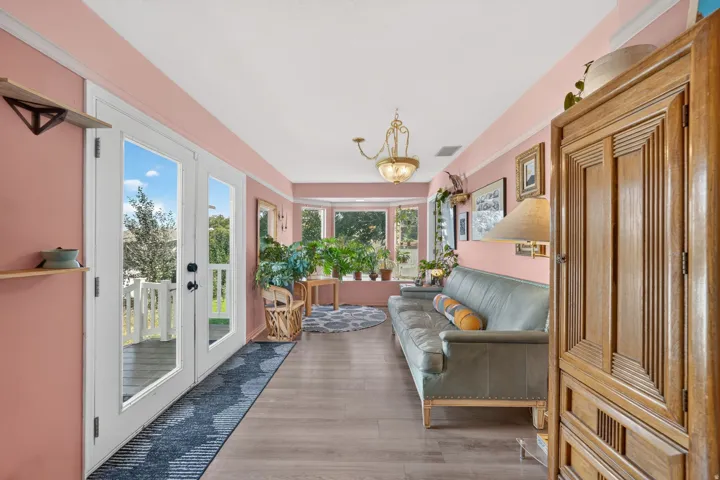 Bay window, French doors, wood-finish flooring, crown molding, chandelier