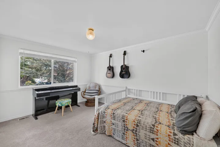 Single-pane window, crown molding, chair rail molding, wall-to-wall carpeting, and a ceiling-mounted light fixture