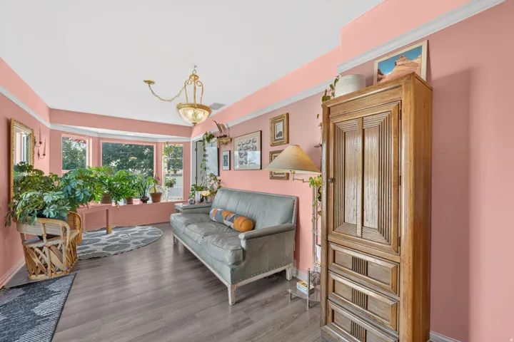 Wood-finish flooring, bay window, light fixture, crown molding, wall-mounted mirror