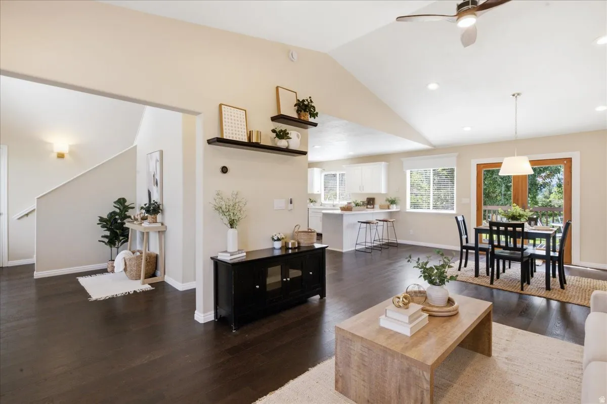 Vaulted ceilings, wood-finish flooring, recessed lighting, and a ceiling fan