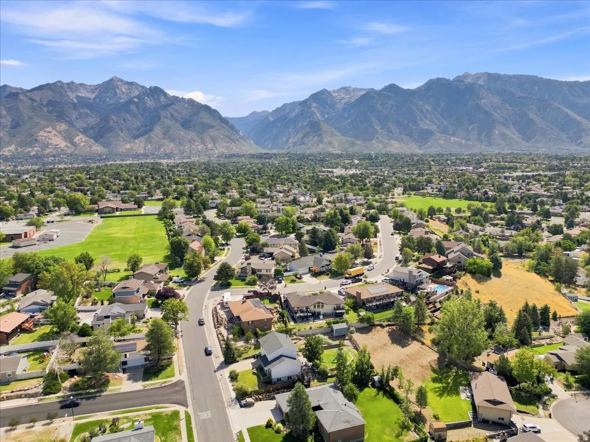Expansive mountain scenery framing a residential area with varied housing styles and mature trees