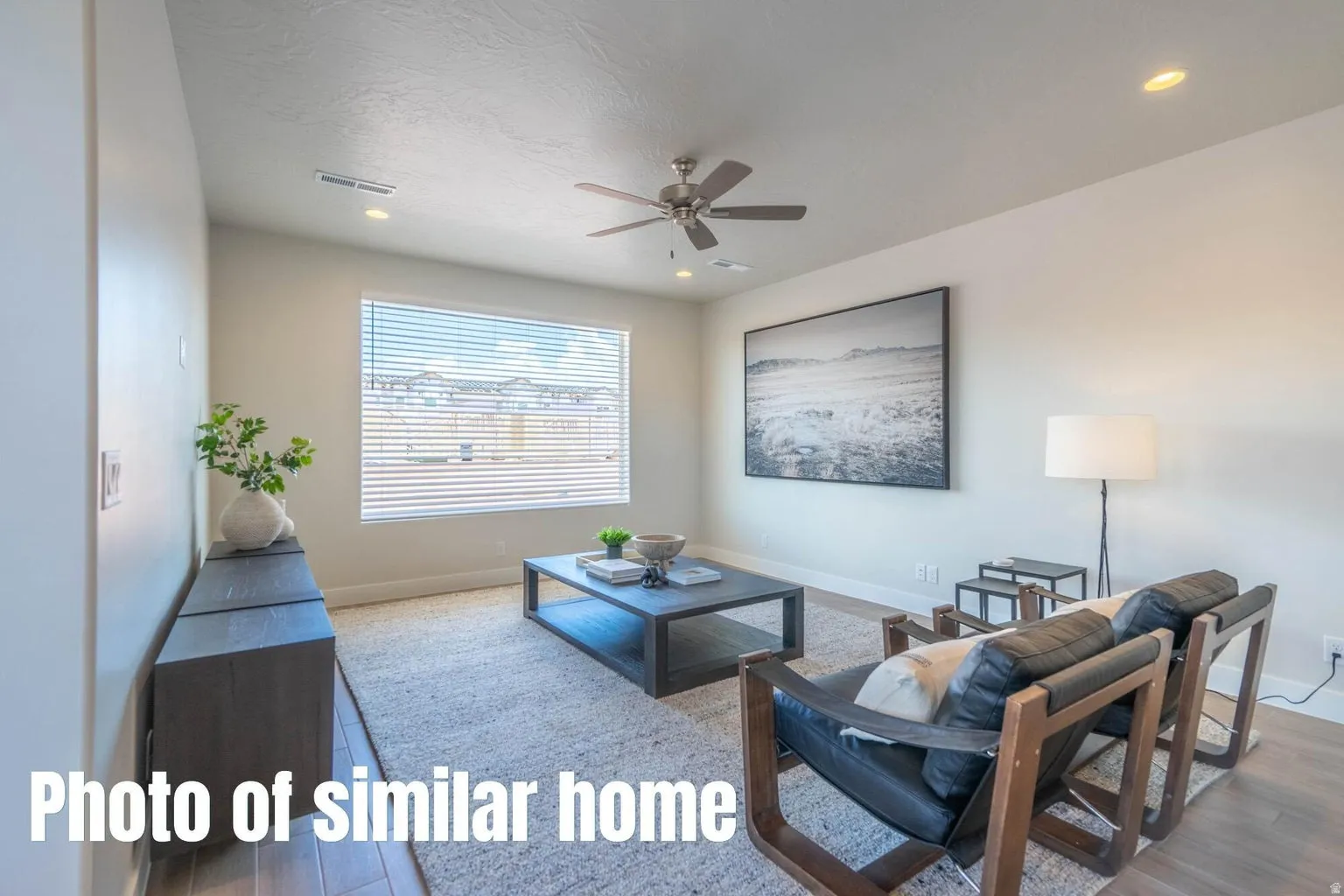 Recessed ceiling lighting, a ceiling fan, and wood-finish flooring
