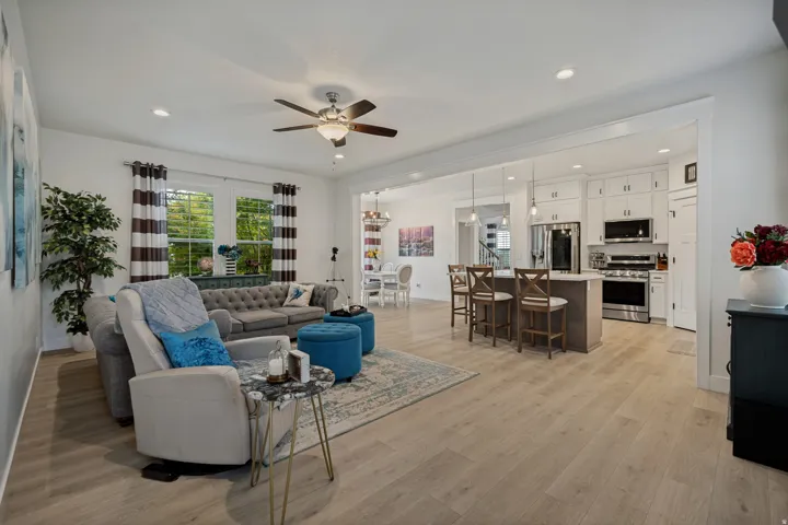 Open-concept living area featuring wood-finish flooring, recessed lighting, and a ceiling fan