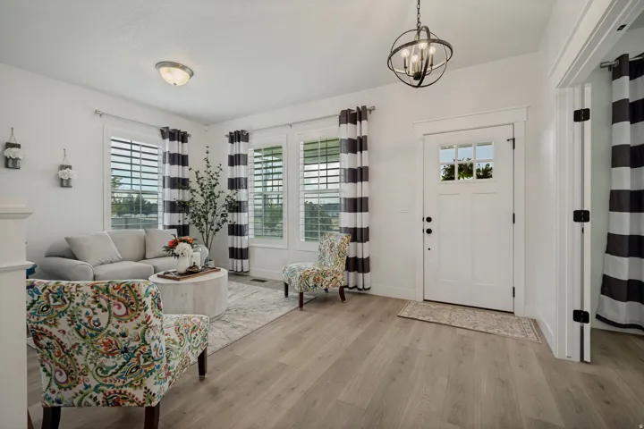 Entryway featuring wood-finish flooring, a white paneled door with windowpanes, and an orb chandelier
