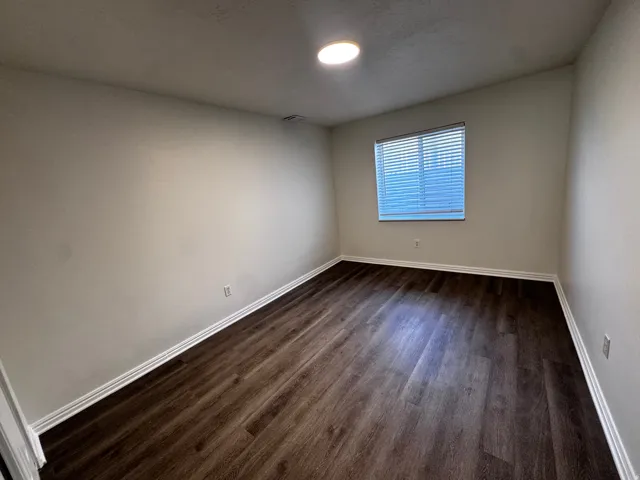 Recessed ceiling lighting, wood-finish flooring, window with blinds, and white trim