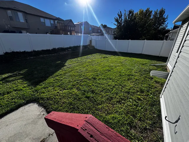 Expansive grassy yard area with perimeter fencing