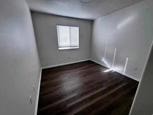 Wood-finish flooring, white trim, window with blinds, and recessed ceiling light