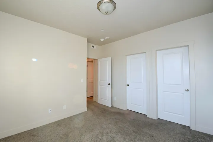 Plush carpeting, neutral wall finishes, flush mount ceiling light fixture, and white two-panel interior doors