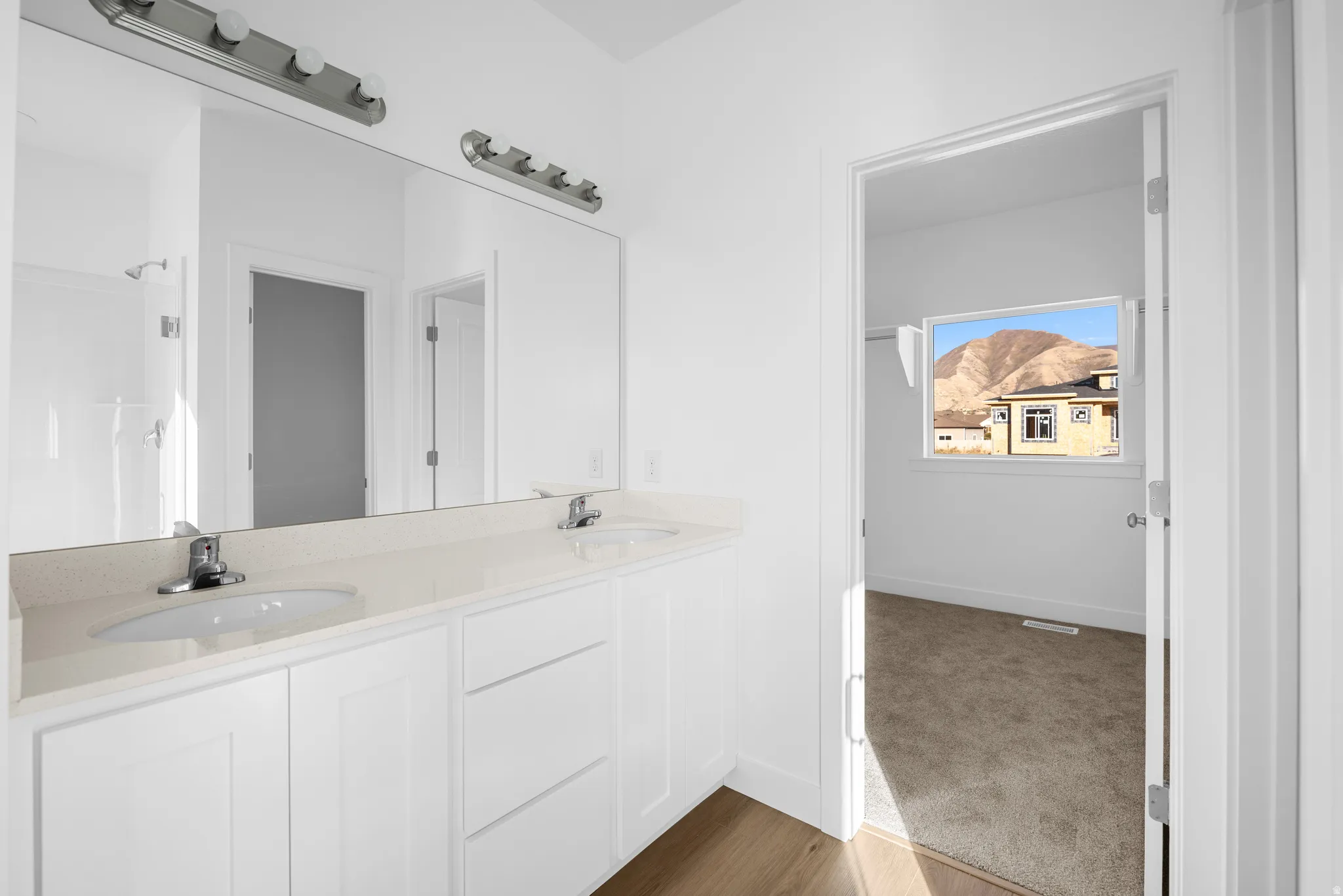 Dual vanity with integrated sinks, spacious countertop, and modern light fixtures