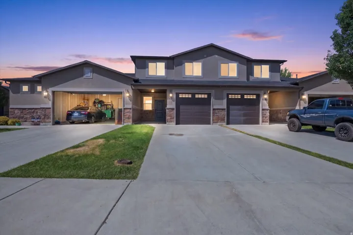 Siding exterior with stone accents, multiple garage doors, and concrete driveways