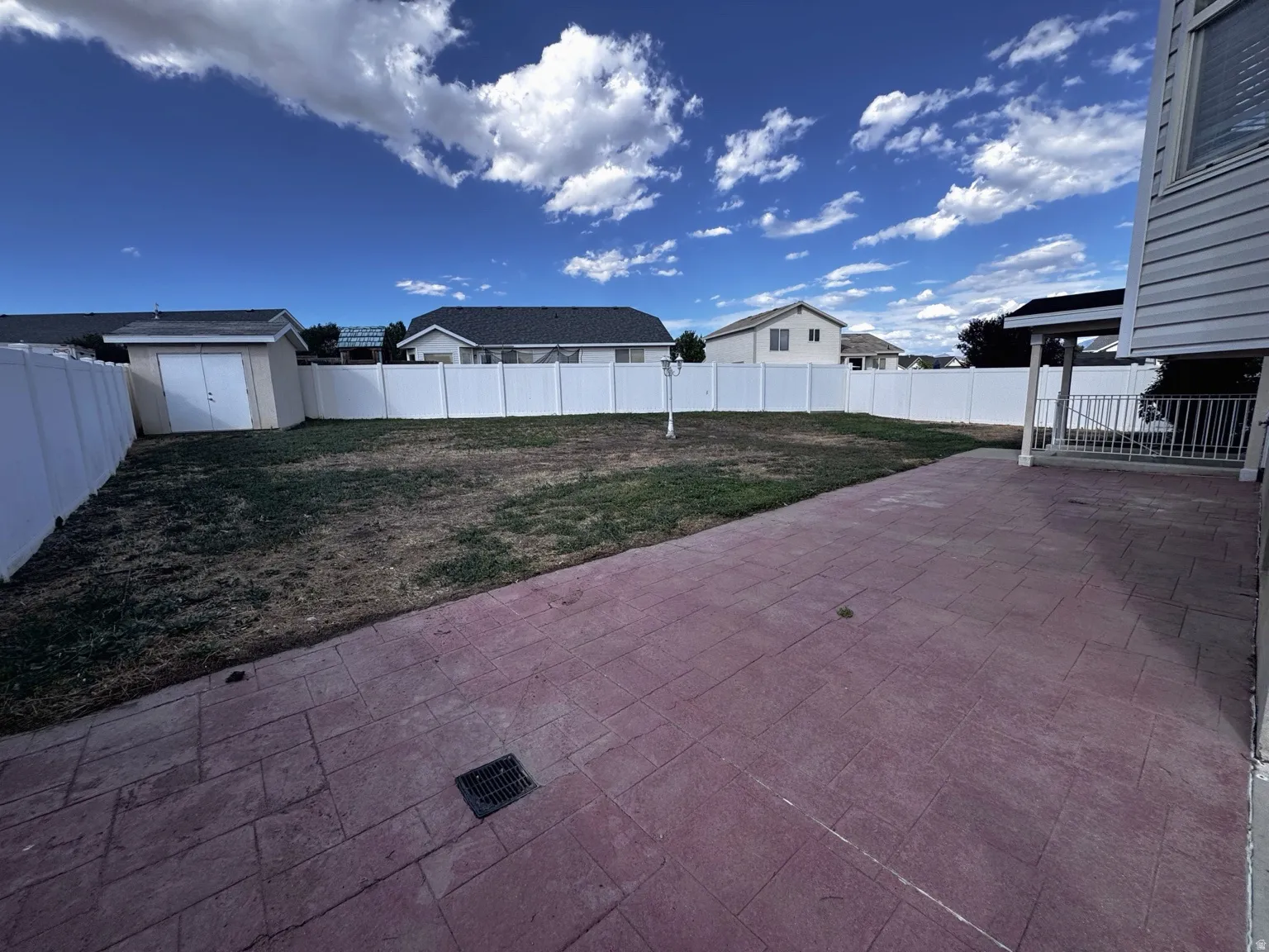 Stamped concrete patio, fully fenced yard, detached storage shed, covered porch area, and exterior siding