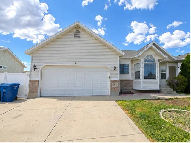 Two-car garage, bay window, arched window, vinyl siding exterior, and brick accents