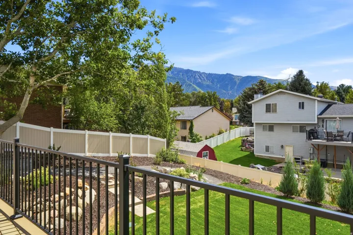 Expansive backyard featuring a manicured lawn, established landscaping, and a two-tone fence