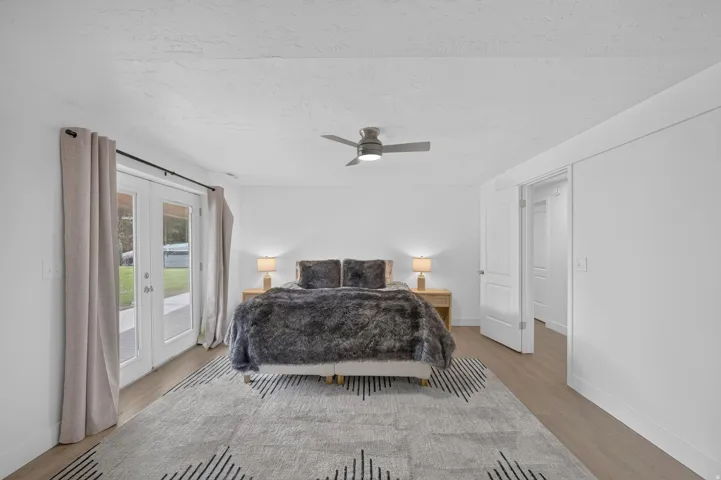 Recessed lighting, ceiling fan, wood-finish flooring, white double doors, and white paneled doors