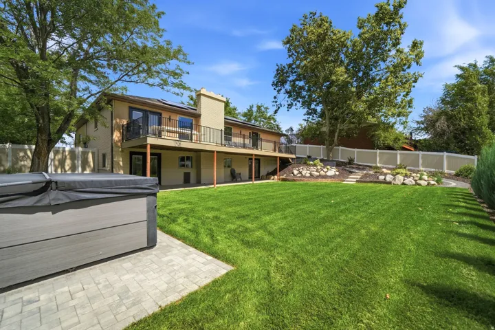 Expansive green lawn with a tiered landscaped area featuring rocks and foliage