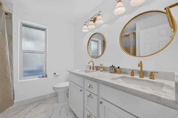 Dual vanity with gold-finish fixtures and hardware