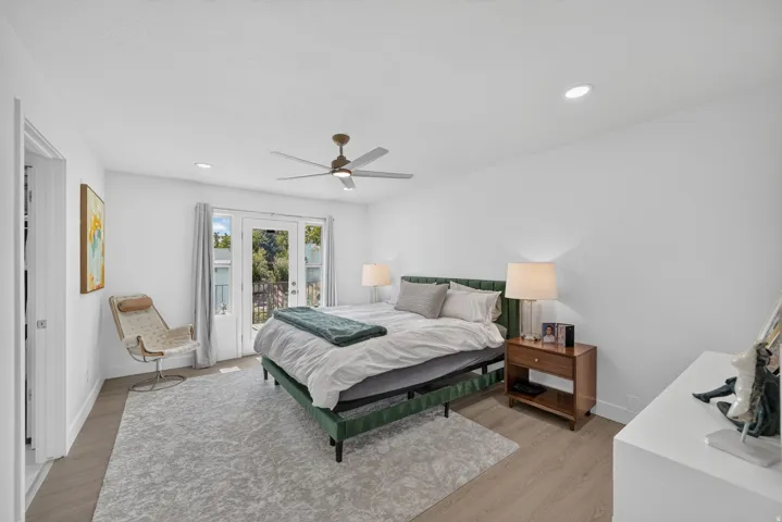 Recessed lighting, ceiling fan, wood-finish flooring, and double doors to outdoor space