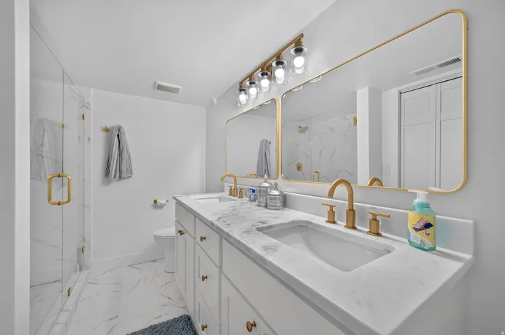 Dual vanity with marble-finish countertop and gold-tone fixtures