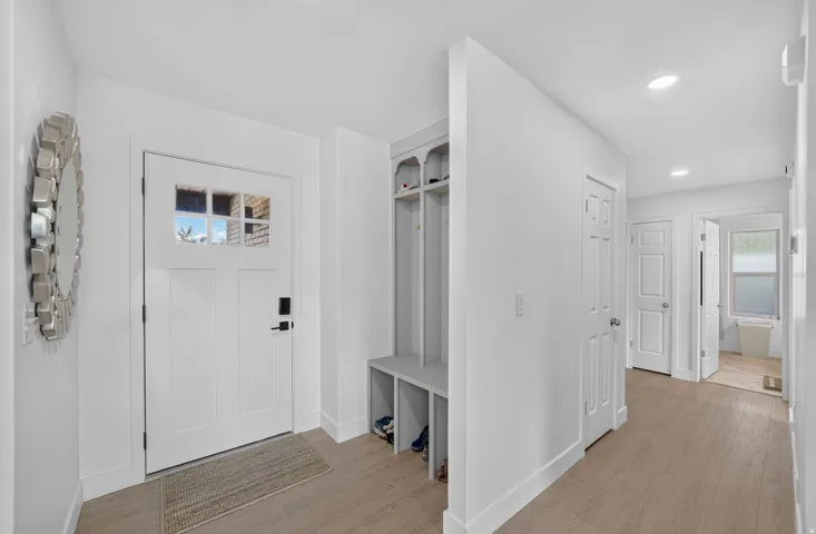 Entryway featuring a paneled door with windowpanes, recessed lighting, wood-finish flooring, and built-in storage
