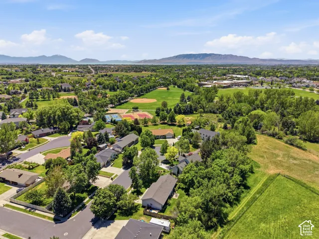 Aerial perspective of  cul-de-sac and neighborhood. Featuring extensive greenery, mature trees, and mountainous terrain in the distance