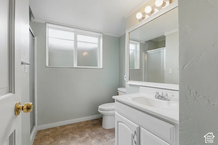 White vanity with a single basin sink, chrome faucet, and integrated mirror with vanity lighting