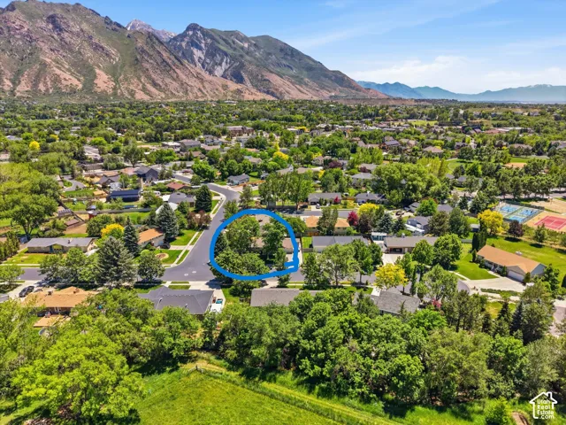 Aerial perspective of cul-de-sac and neighborhood. Featuring mature trees and mountainous backdrop