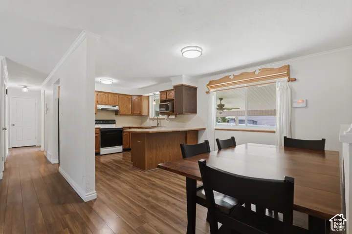 Kitchen featuring wood-finish cabinetry, built-in microwave, and breakfast bar