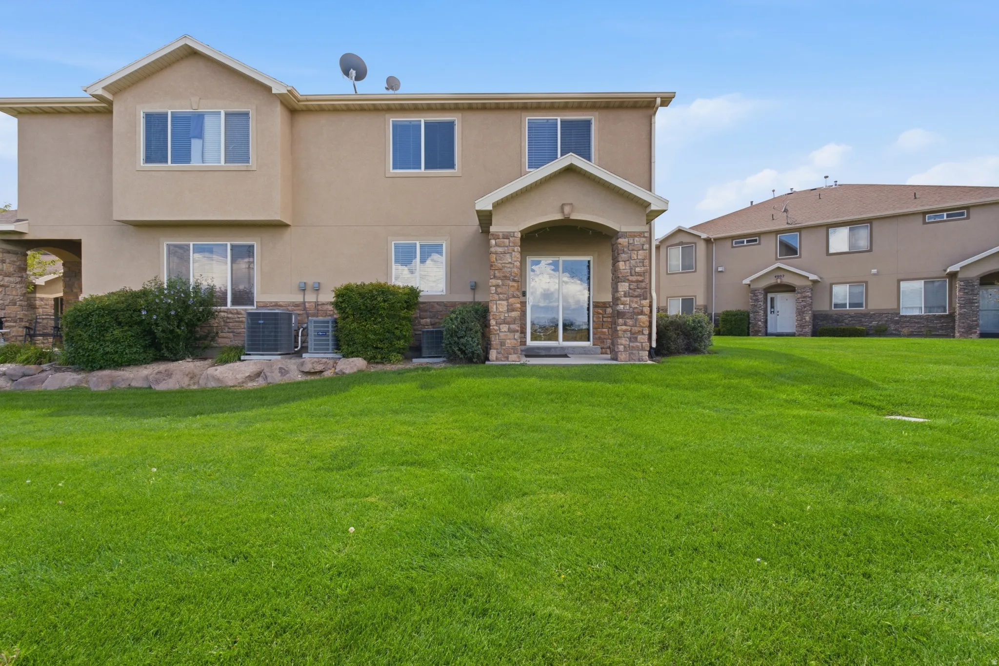 Two-story stucco exterior with stone accents