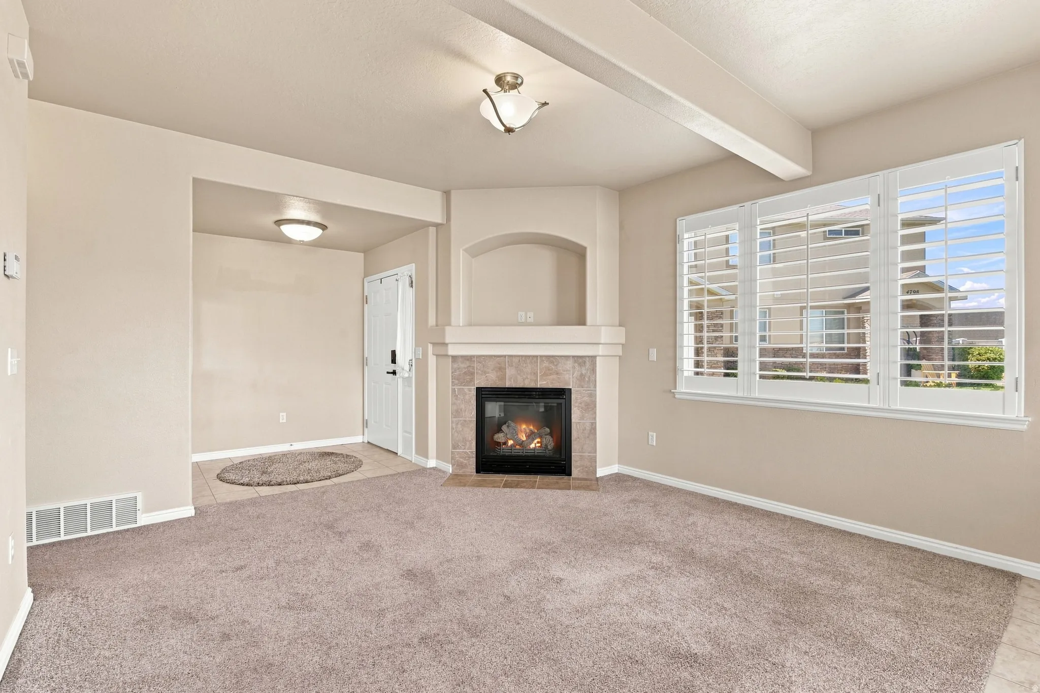 Corner fireplace with a tiled surround, arched alcove, and mantel
