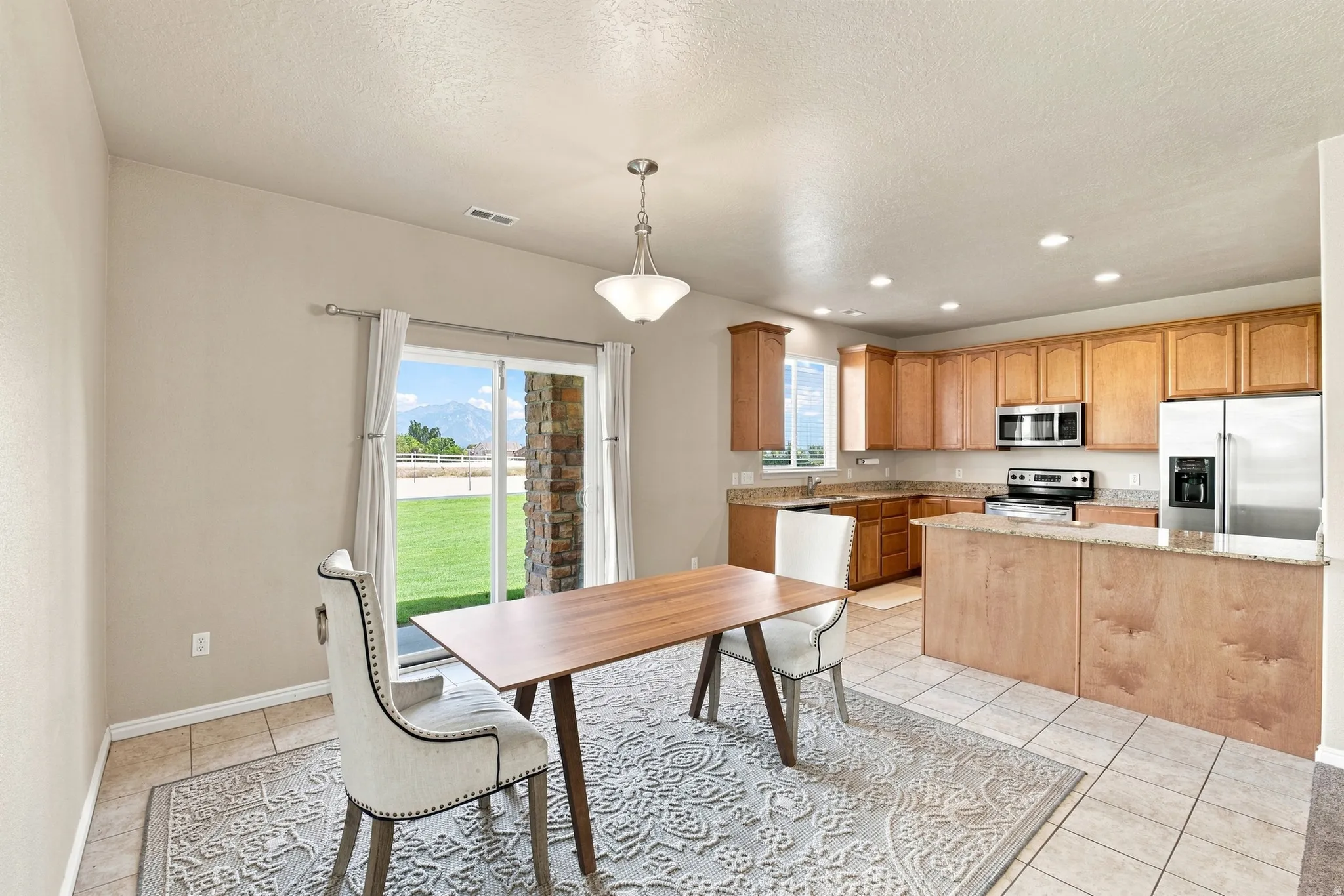 Kitchen featuring wood-finish cabinetry, stainless steel appliances, and granite countertops