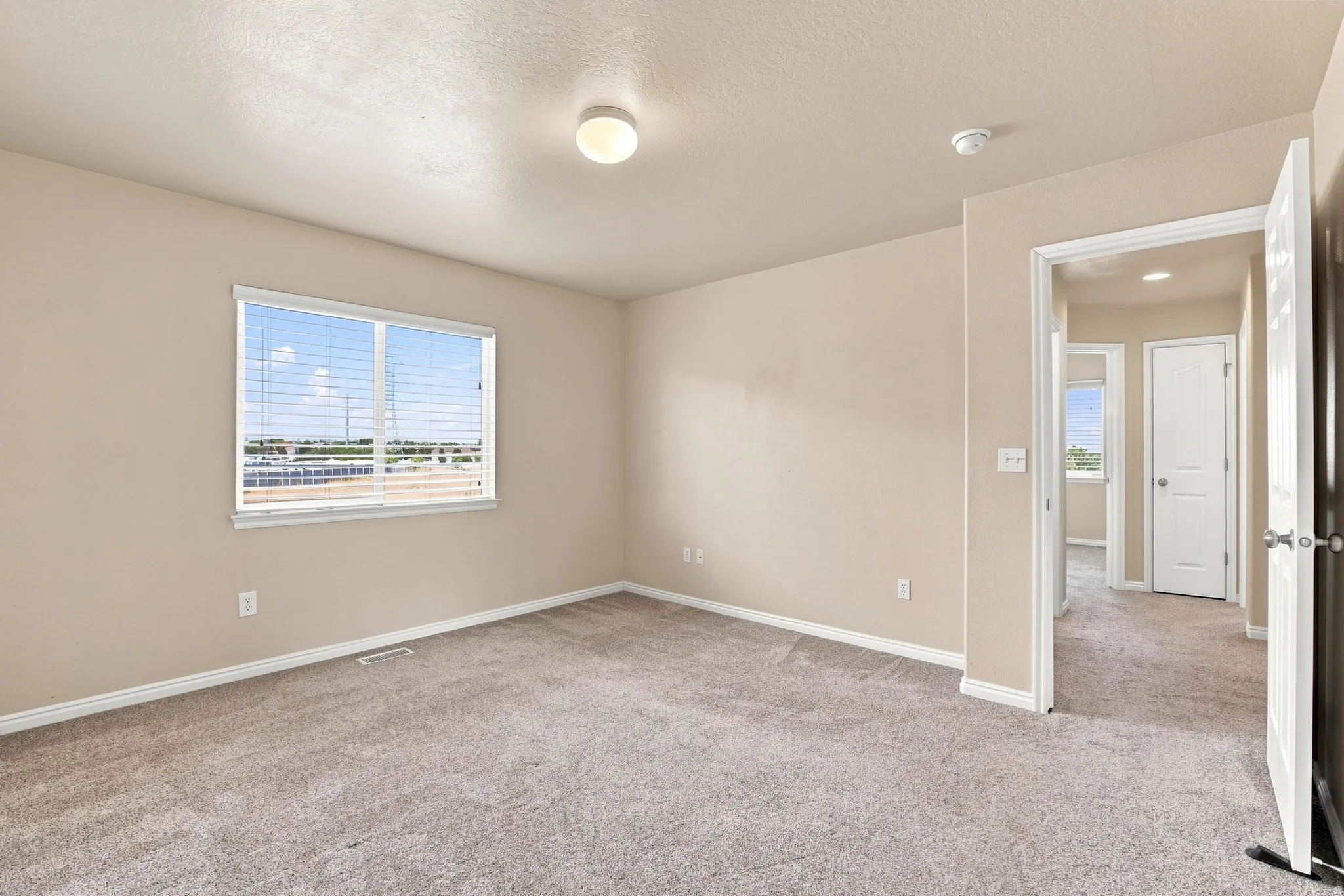 Neutral wall paint with coordinating trim, carpeted flooring, and a flush mount ceiling light