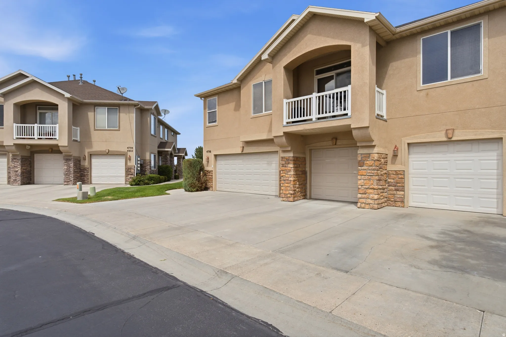 Multi-level townhome architecture featuring stucco and stone veneer