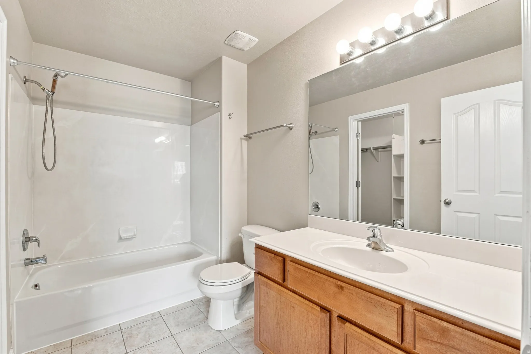 White bathtub and shower combination with chrome fixtures