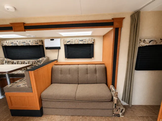 living area w/couch in travel trailerWood-finish flooring with a textured wall covering