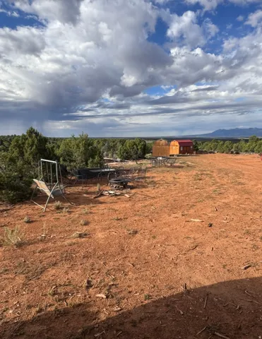 Expansive natural landscape with visible outbuildings and distant mountain scenery