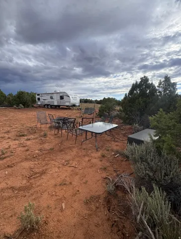 yard with table, chairs, firepit and travel trailer