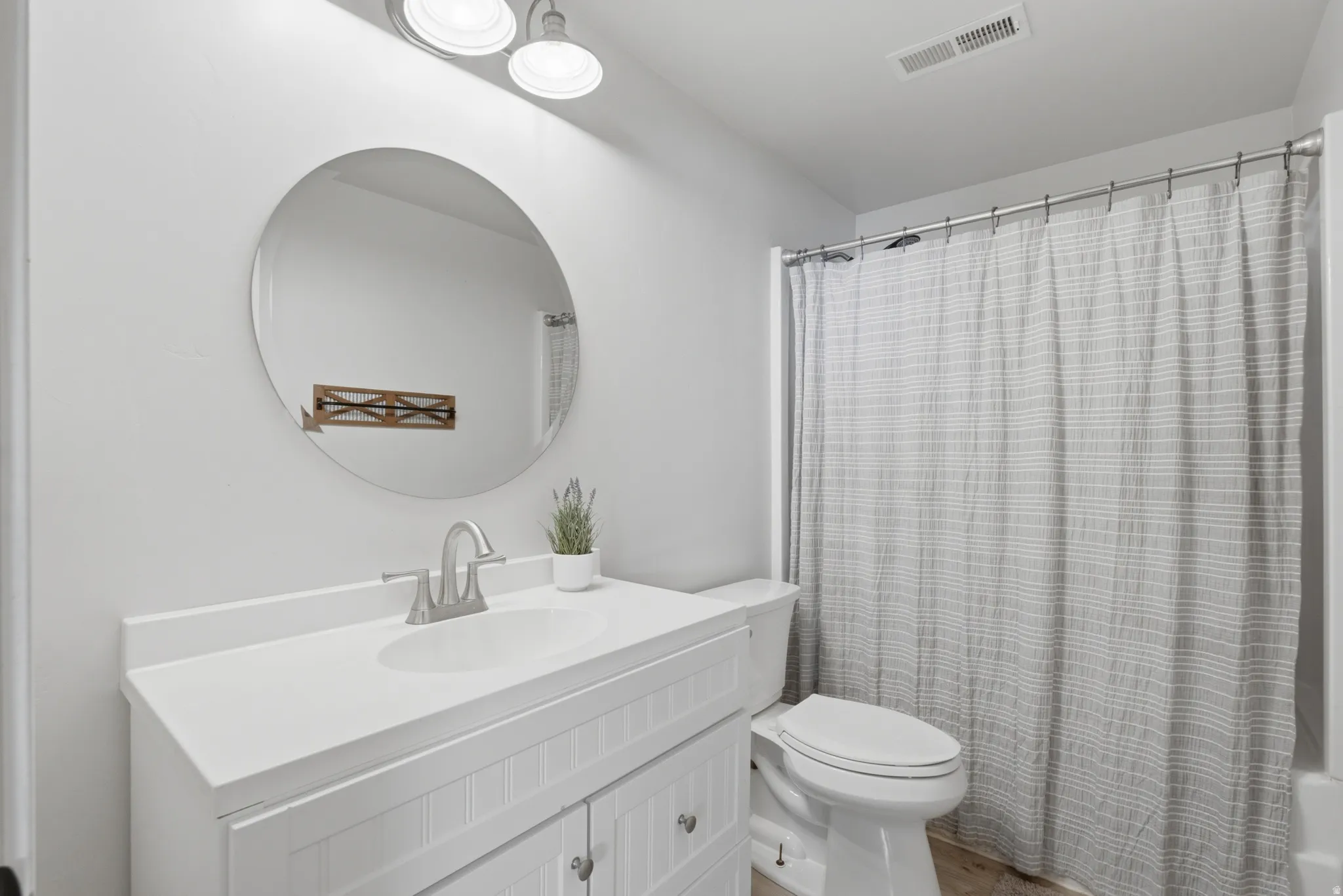 White beadboard vanity with a white countertop and an integrated sink