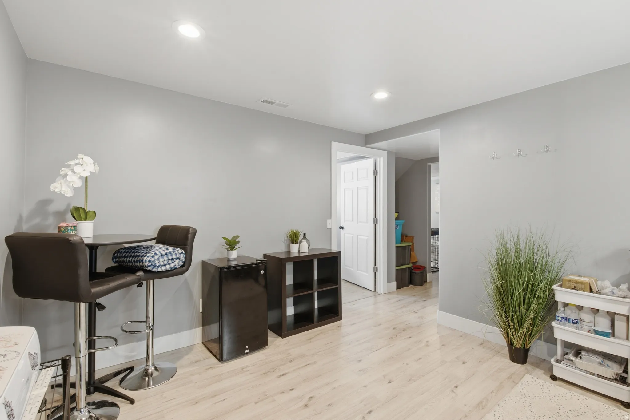 A second living room space that also can be used as an office, play area, or work out room. Light wood-finish flooring with recessed lighting and neutral wall tones