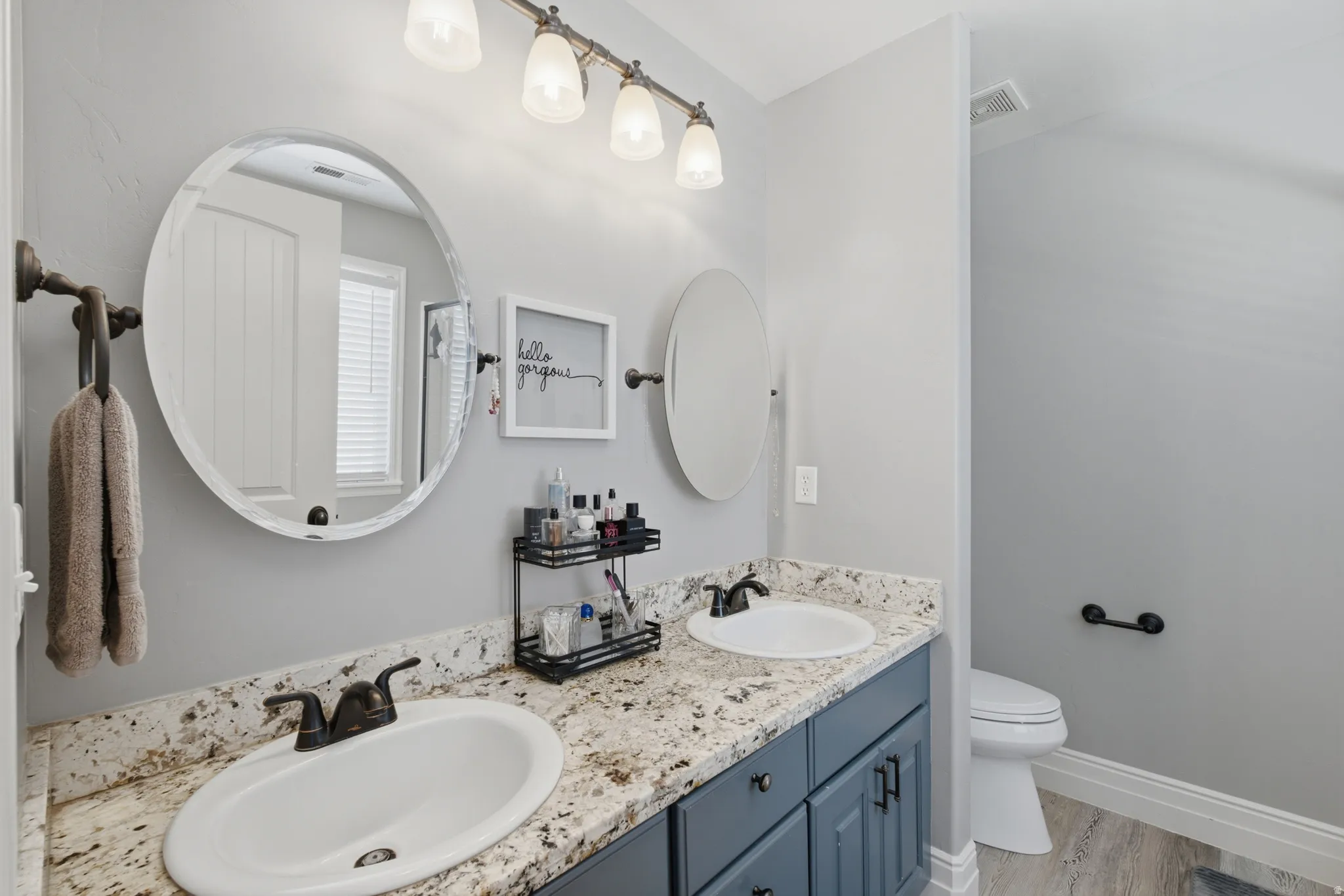 Owners ensuite with dual vanity sinks, granite-style countertop, and dark-finish cabinetry