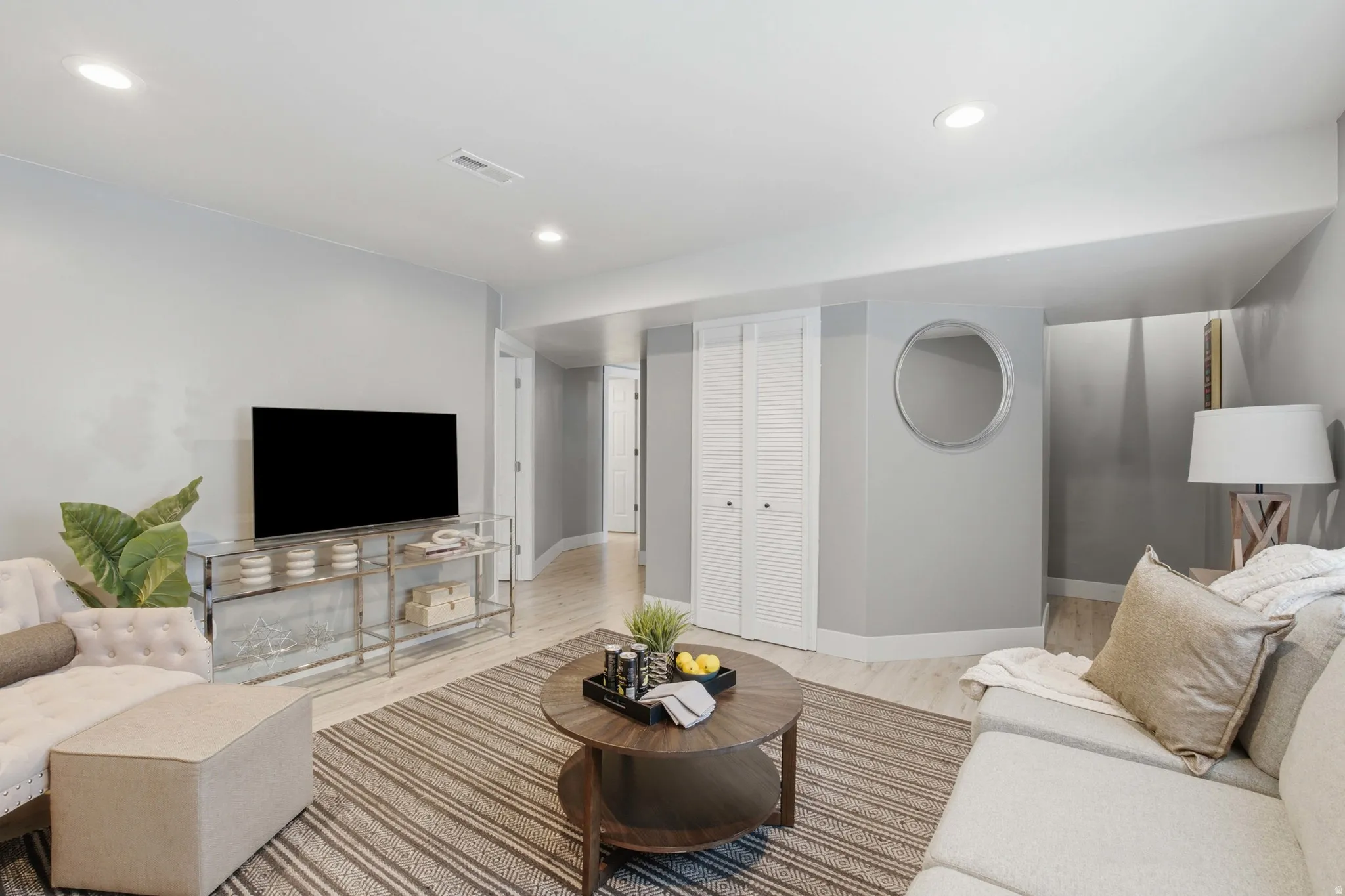Recessed lighting, light-toned wood-finish flooring, white louvered closet doors, and light gray wall paint